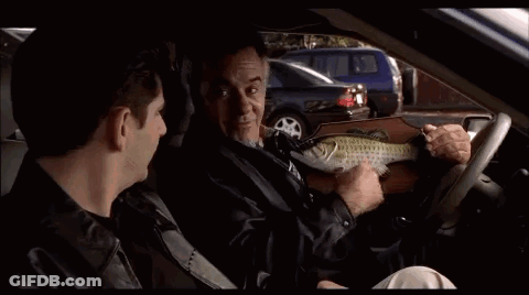 A Man Is Sitting In The Driver 'S Seat Of A Car With Another Man . GIF