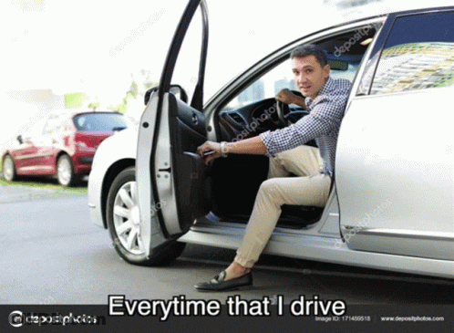 A Man Is Sitting In The Driver 'S Seat Of A Silver Car . GIF