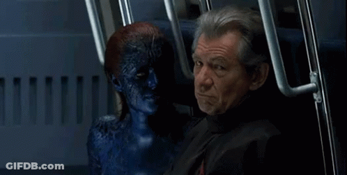 A Man Is Sitting Next To A Blue Monster With A Smile On His Face GIF