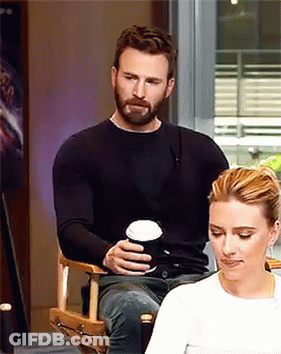 A Man Is Sitting Next To A Woman Holding A Cup Of Coffee GIF