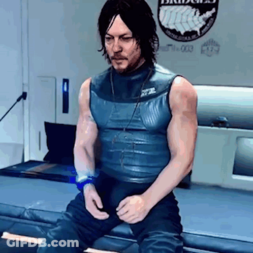 A Man Is Sitting On A Bed In A Room With A Badge On The Wall . GIF