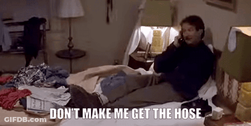 A Man Is Sitting On A Bed Talking On A Cell Phone . GIF