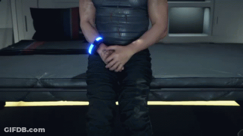 A Man Is Sitting On A Bed With His Hands On His Pants GIF