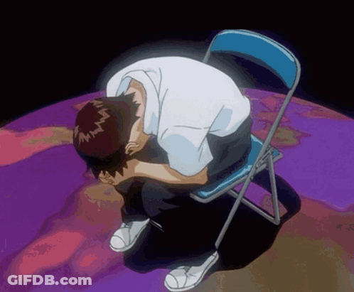 A Man Is Sitting On A Blue Chair With His Head In His Hands GIF