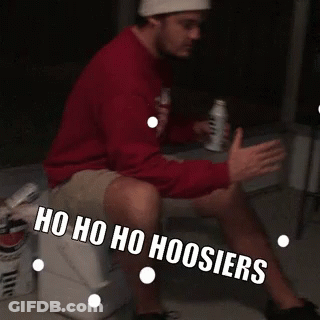 A Man Is Sitting On A Cooler With The Words Ho Ho Ho Hoosier Written On His Leg GIF