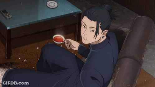 A Man Is Sitting On A Couch Drinking A Cup Of Coffee GIF