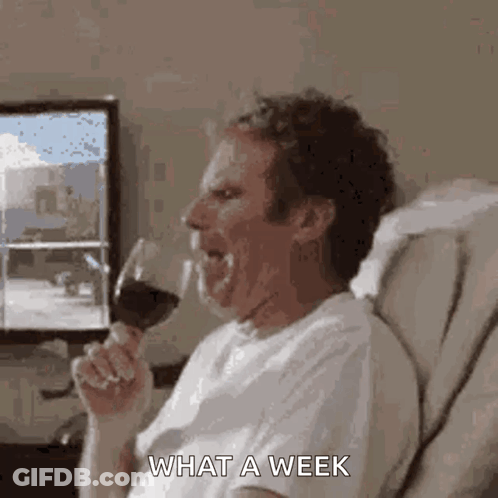 A Man Is Sitting On A Couch Drinking A Glass Of Wine And Making A Funny Face . GIF