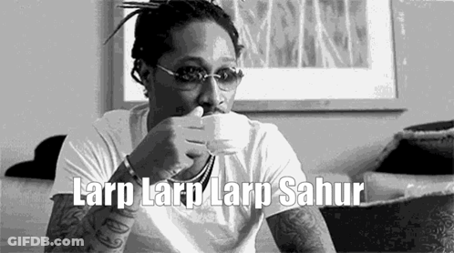 A Man Is Sitting On A Couch Drinking From A Cup . GIF