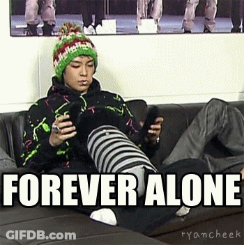 A Man Is Sitting On A Couch Holding A Cell Phone With The Words Forever Alone Above Him . GIF