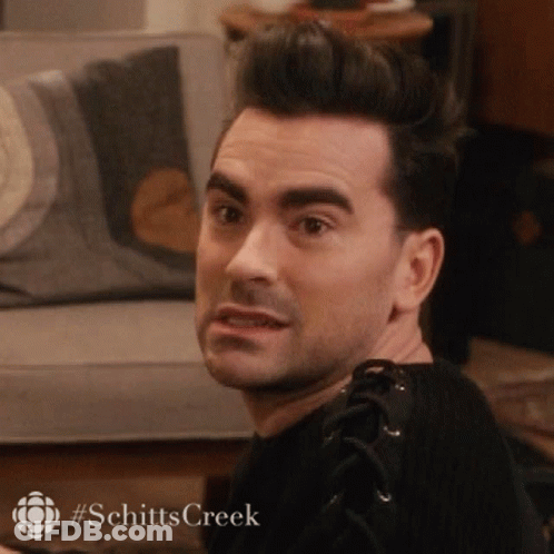A Man Is Sitting On A Couch In A Living Room And Making A Face . GIF