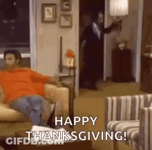 A Man Is Sitting On A Couch In A Living Room With The Words `` Happy Thanksgiving ! '' GIF