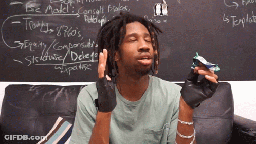 A Man Is Sitting On A Couch In Front Of A Blackboard That Says Biz Model On It GIF