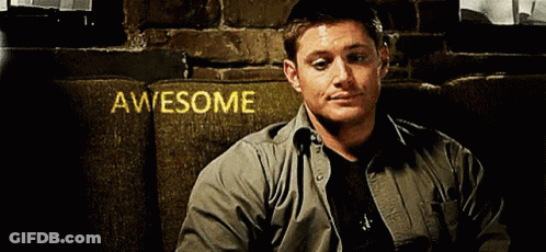A Man Is Sitting On A Couch In Front Of A Sign That Says Awesome On It GIF