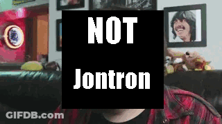 A Man Is Sitting On A Couch In Front Of A Sign That Says Not Jontron . GIF
