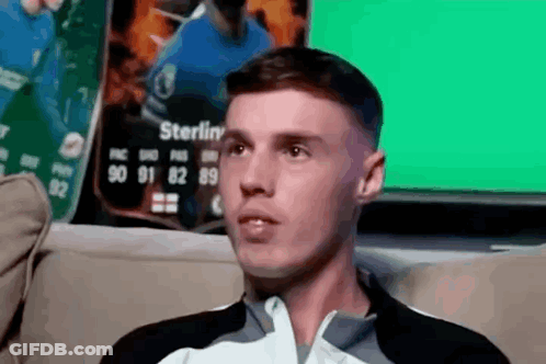 A Man Is Sitting On A Couch In Front Of A Sterling Card GIF