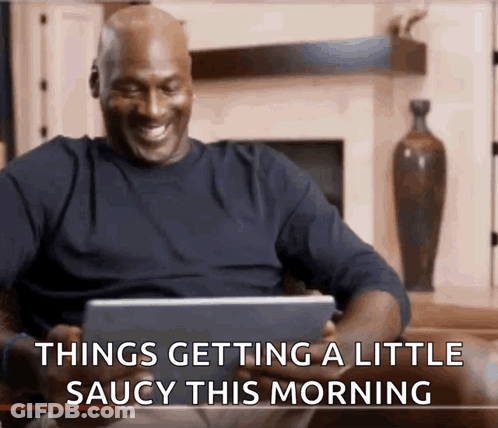 A Man Is Sitting On A Couch Looking At A Tablet With The Words Things Getting A Little Saucy This Morning GIF