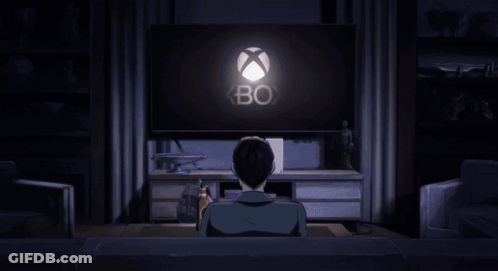 A Man Is Sitting On A Couch Watching A Video Game On A Television GIF