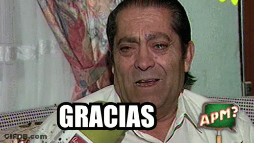 A Man Is Sitting On A Couch With A Gracias Sign Above Him GIF