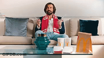 A Man Is Sitting On A Couch With A Mcdonald 'S Bag In Front Of Him . GIF