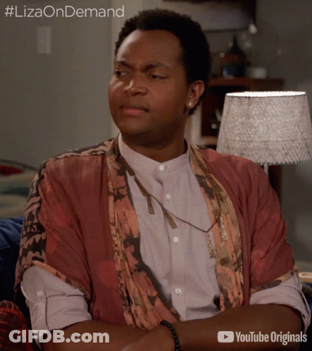 A Man Is Sitting On A Couch With His Arms Crossed And A Youtube Originals Advertisement Behind Him GIF