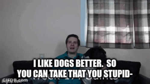 A Man Is Sitting On A Couch With His Dog And Says I Like Dogs Better So You Can Take That You Stupid GIF
