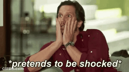 A Man Is Sitting On A Couch With His Hands On His Face And The Words `` Pretends To Be Shocked '' Above Him . GIF