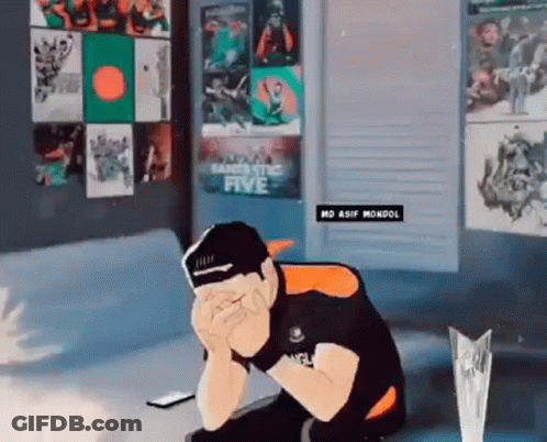 A Man Is Sitting On A Couch With His Head In His Hands In Front Of A Wall With Posters On It . GIF