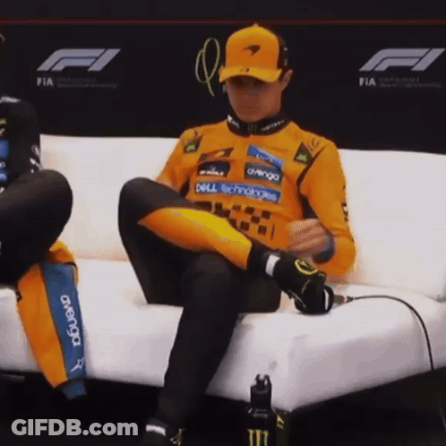 A Man Is Sitting On A Couch With His Legs Crossed And His Shirt Says Dell Technologies On It GIF