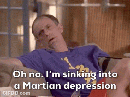 A Man Is Sitting On A Couch With His Legs Crossed And Says Oh No I 'M Sinking Into A Martian Depression GIF