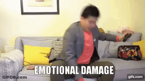 A Man Is Sitting On A Couch With The Words Emotional Damage Written On The Screen GIF