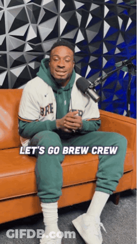 A Man Is Sitting On A Couch With The Words Let 'S Go Brew Crew On The Bottom GIF