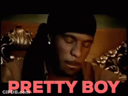 A Man Is Sitting On A Couch With The Words Pretty Boy Behind Him GIF