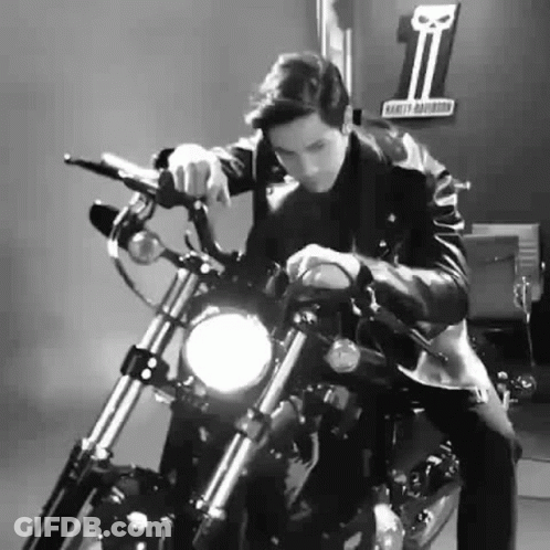 A Man Is Sitting On A Harley Davidson Motorcycle In A Black And White Photo . GIF