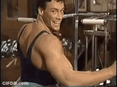 A Man Is Sitting On A Machine In A Gym And Smiling . GIF