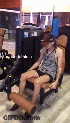 A Man Is Sitting On A Machine In A Gym With The Name Bonitodamidia Written On The Bottom GIF