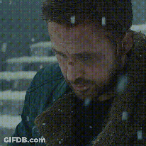 A Man Is Sitting On A Set Of Stairs In The Snow Looking At His Phone GIF