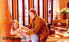 A Man Is Sitting On A Woman 'S Lap In A Living Room . GIF