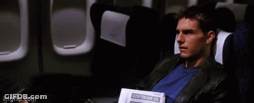 A Man Is Sitting On An Airplane Reading A Newspaper That Says " Travel " GIF