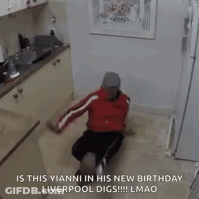 A Man Is Sitting On The Floor In A Kitchen And Dancing . GIF