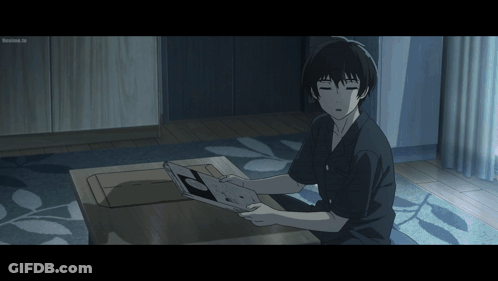 A Man Is Sitting On The Floor Looking At A Book And The Screen Says ' Tokyo Ghoul ' On The Bottom GIF
