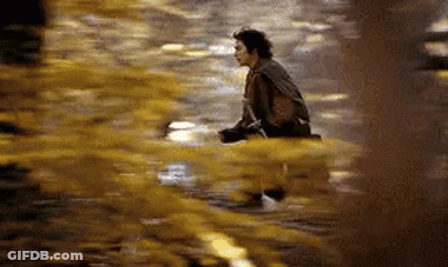 A Man Is Sitting On The Ground In A Puddle Of Water . GIF