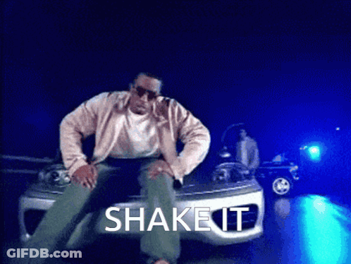A Man Is Sitting On The Hood Of A Car With The Words Shake It Written Above Him GIF