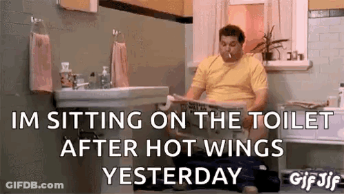 A Man Is Sitting On The Toilet Reading A Newspaper . GIF
