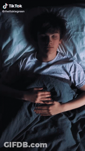 A Man Is Sleeping In A Bed With A Tiktok Watermark GIF