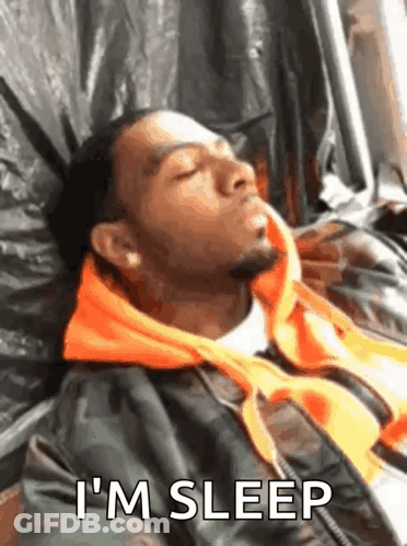 A Man Is Sleeping On A Bed With The Words `` I 'M Sleep '' Written Next To Him . GIF
