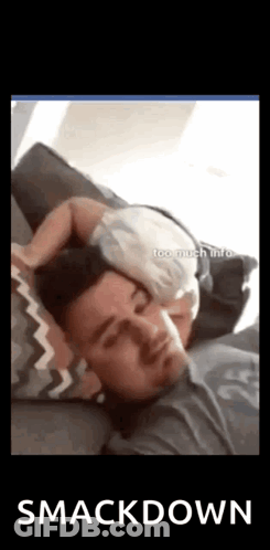 A Man Is Sleeping With A Baby On His Head . GIF