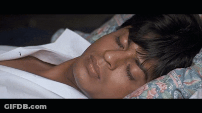 A Man Is Sleeping With His Eyes Closed And His Shirt Off GIF