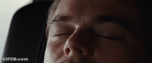 A Man Is Sleeping With His Eyes Closed In A Car Seat GIF