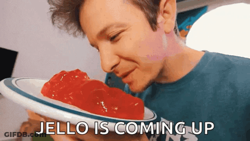 A Man Is Smelling A Plate Of Jello With The Words Jello Is Coming Up Below Him GIF