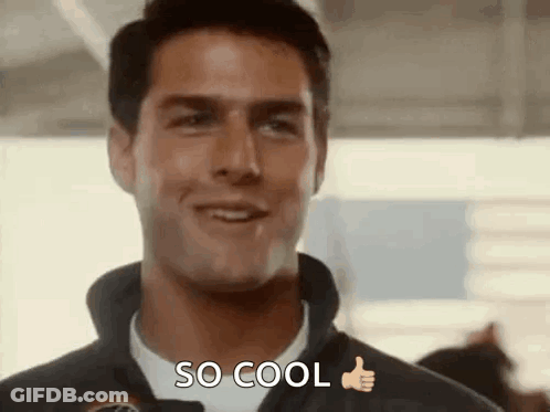 A Man Is Smiling And Giving A Thumbs Up While Wearing A Jacket And A White Shirt . GIF